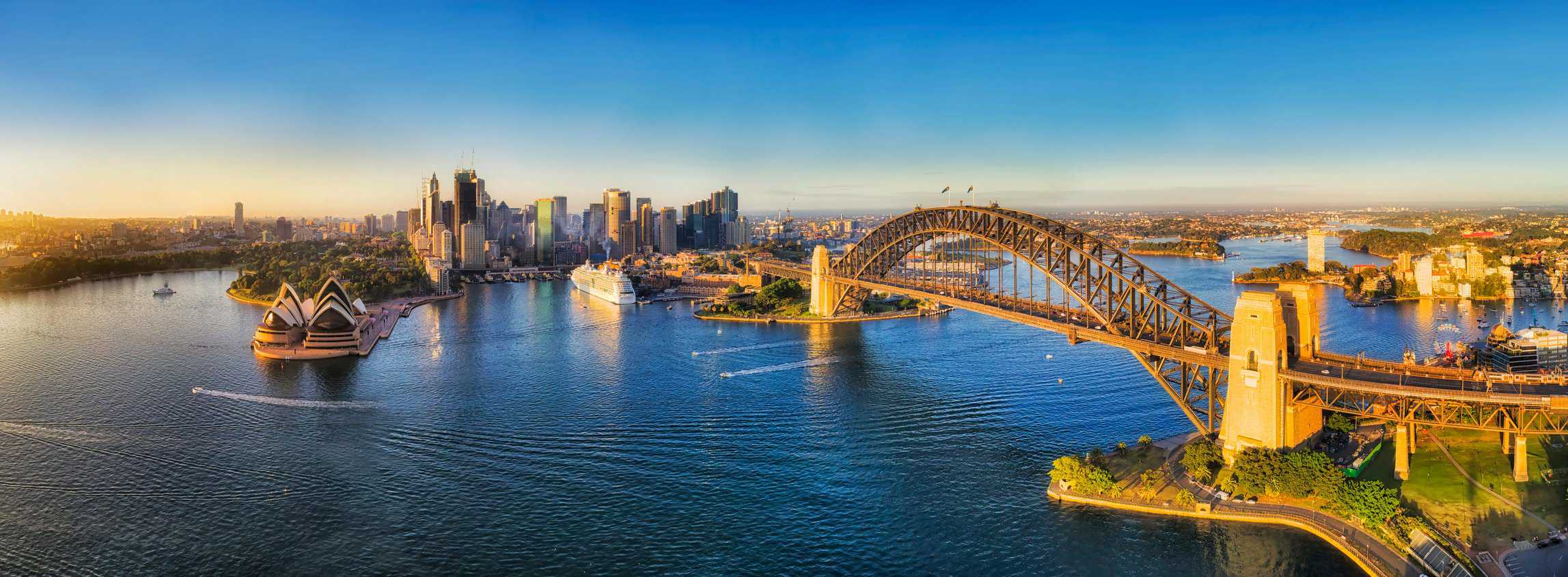 RN323Y Warm and soft morning sun light on major Sydney city CBD Landmarks around Sydney harbour viewed from above - aerial wide panorama facing Cicrular Quay